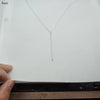 Silver stick pendant bar necklace featuring a hollow geometric design displayed on white paper.