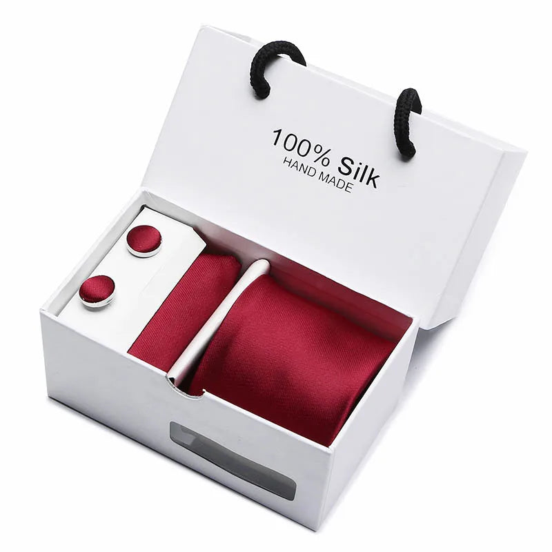 Una corbata de cuello de jacquard de seda azul marino con estampado de cachemira y forro rojo, en una caja blanca.