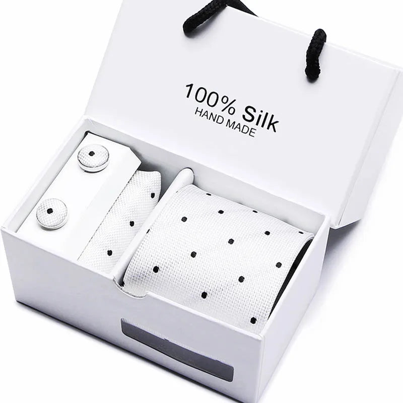 Caja blanca con corbata de seda jacquard azul marino y estampado de cachemir, etiqueta artesanal.
