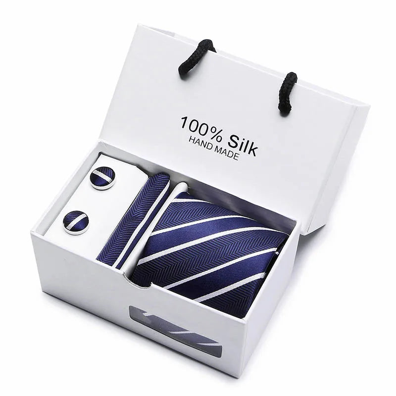 Corbata de seda jacquard azul marino con estampado de cachemira en una caja blanca con detalles plateados.