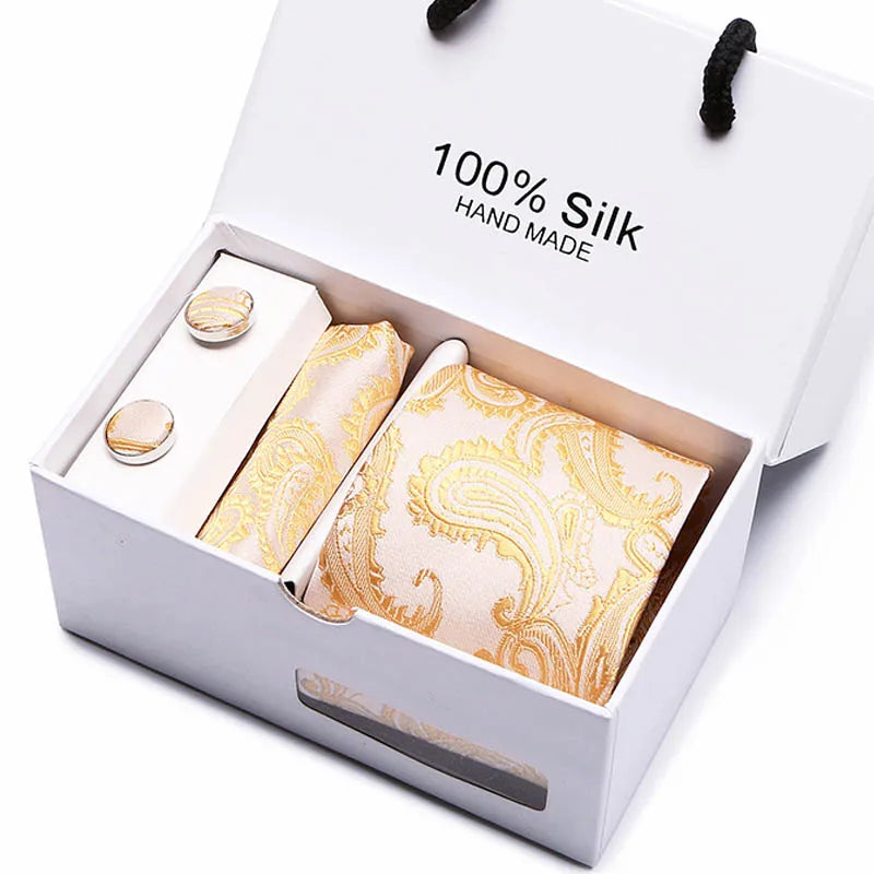 Caja blanca con una corbata de seda dorada hecha a mano con diseño paisley.