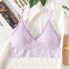 A light purple seamless U-back bralette with thin straps and removable pads displayed on a white fabric.