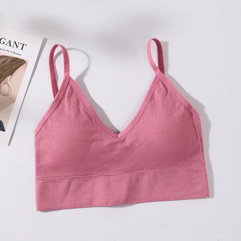 A pink seamless U-back bralette top with adjustable straps and removable pads displayed on a white background.