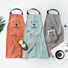 Three fabric aprons shaped like bears in orange, mint green, and gray laid on a white surface.