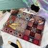 A colorful patchwork fabric featuring bohemian mandala patterns laid on a white surface.