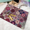 A colorful fabric featuring intricate bohemian mandala patterns, laid out on a white fluffy surface.