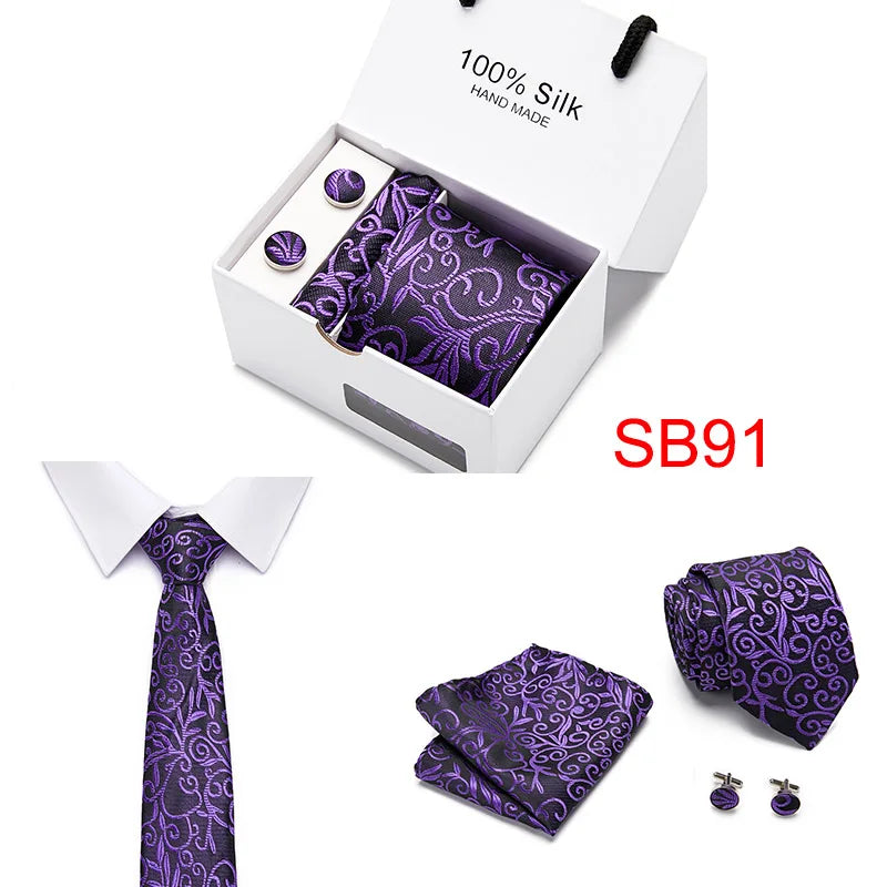 Caja con corbata de seda morada artesanal de cachemira y otra corbata sobre fondo blanco.