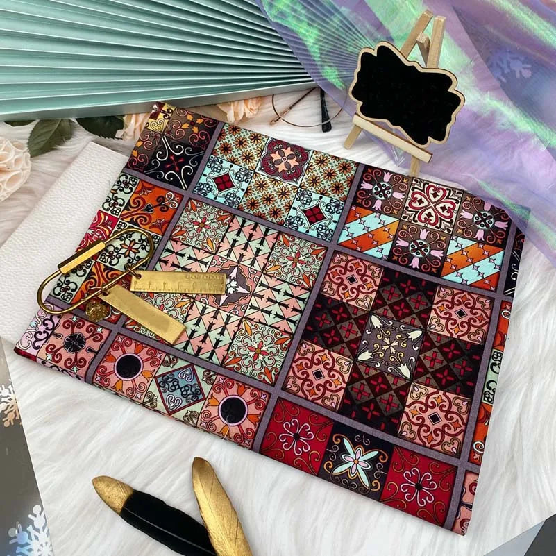 A colorful patchwork fabric featuring bohemian mandala patterns laid on a white surface.