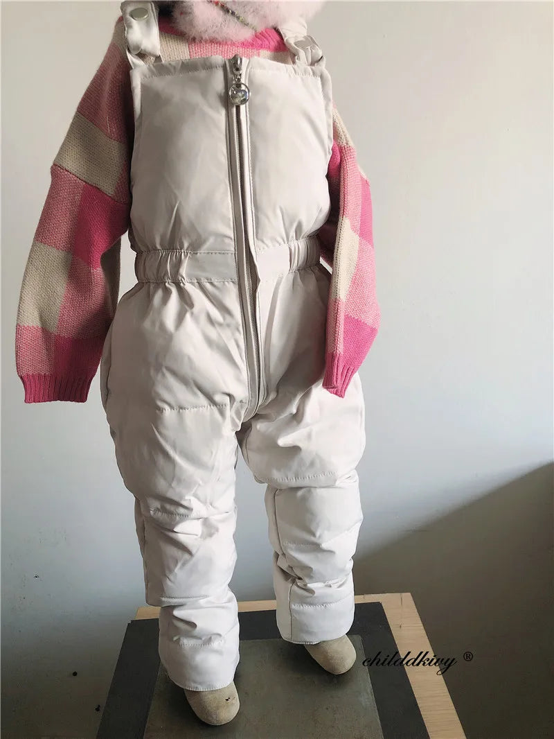 A baby winter down jacket and pants set in white with pink checkered sleeves and a faux fur hood.