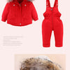 A red baby winter down jacket and pants set with a faux fur hood.