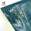 Close-up of dark teal crocodile pattern faux leather fabric for crafting