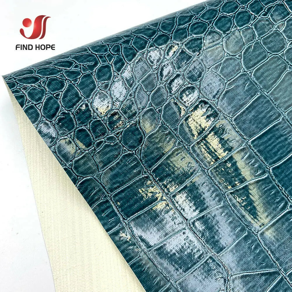 Close-up of dark teal crocodile pattern faux leather fabric for crafting