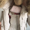 A close-up view of a baby winter down jacket and pants set with a faux fur hood, shown on a mannequin.