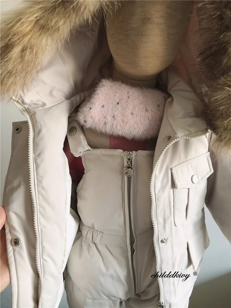 A close-up view of a baby winter down jacket and pants set with a faux fur hood, shown on a mannequin.