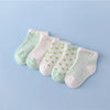 A set of five pastel colored striped cotton baby socks laid out on a light blue background.