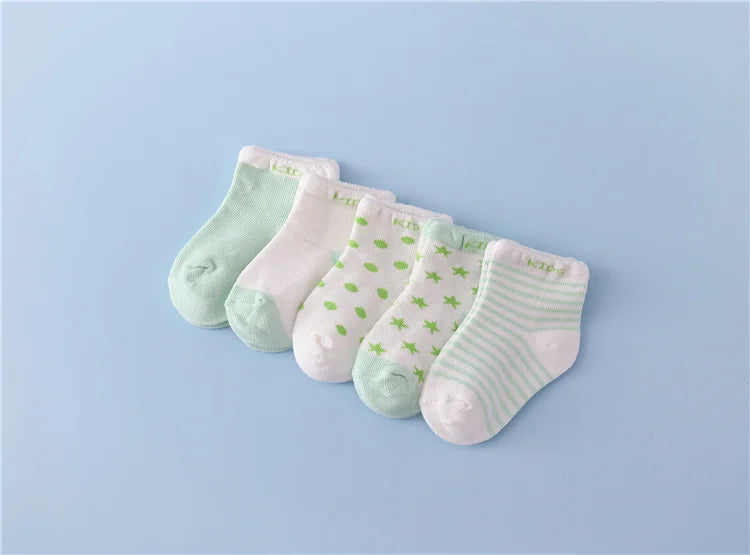 A set of five pastel colored striped cotton baby socks laid out on a light blue background.