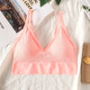 A peach colored seamless U-back bralette top displayed on a white fabric with a design book in the background.