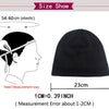 A black knitted beanie hat shown with size measurements for elastic fit.