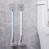 A pair of light blue and white golf-style silicone toilet brushes with self-opening holders mounted on a wall.