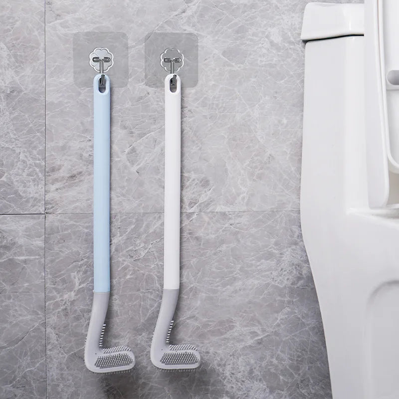 A pair of light blue and white golf-style silicone toilet brushes with self-opening holders mounted on a wall.