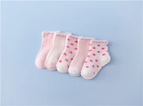 A set of pink baby socks with a white pattern laid out on a light blue background.