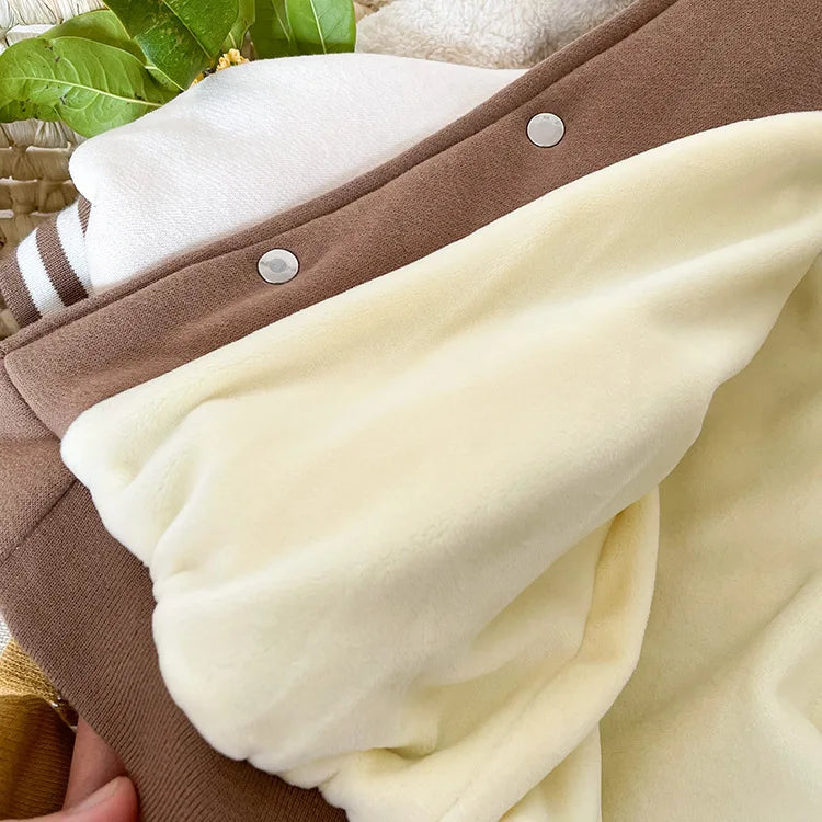 A close-up of a brown corduroy jacket with a cream fleece lining and white trim.