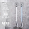 A pair of long handled silicone toilet brushes in white and light blue are shown against a gray tiled background.