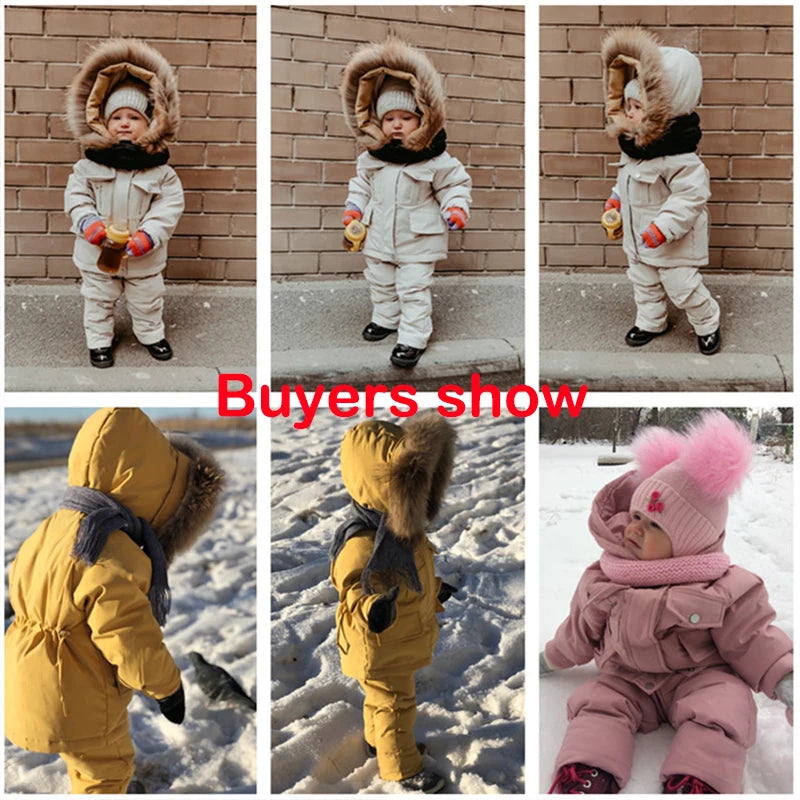 A baby wearing a yellow winter down jacket and pants set with a faux fur hood standing outdoors.