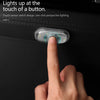 A finger touches a sensor switch on a dark surface, illuminating the area with light.