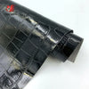 Close-up view of black crocodile pattern faux leather fabric roll for crafting