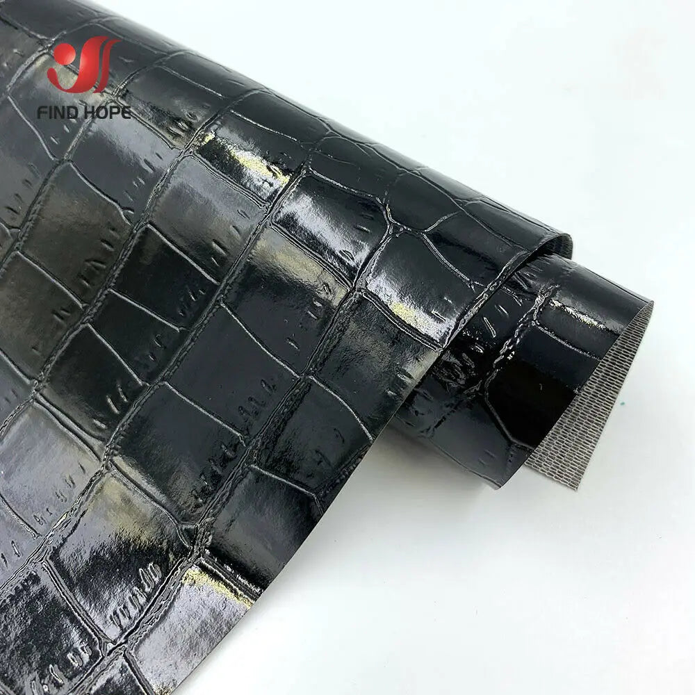 Close-up view of black crocodile pattern faux leather fabric roll for crafting