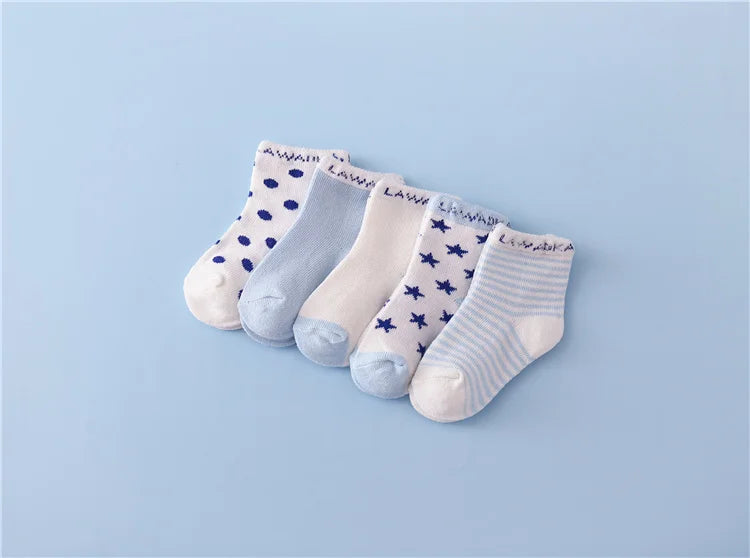 A set of five baby socks featuring various patterns including polka dots and stripes on a light blue background.