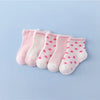 A set of pink and white striped cotton baby socks laid out on a light blue background.