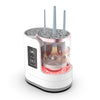 A white electric makeup brush cleaner device with a pink top section and multiple brush holders.