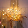 Hvide birkegrene med eventyrlys og varme hvide LED i en hvid vase mod lys baggrund.