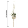 En håndlaget macramé-plantekurv med hvit potte og hengende macramé-tråder til innendørs eller utendørs dekor.