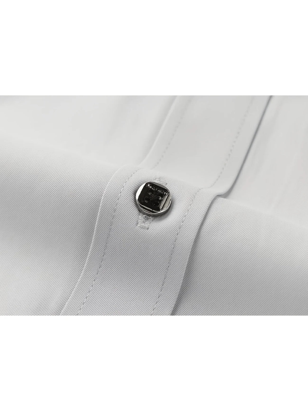 Close-up of a white long-sleeve formal shirt cuff with a silver button detail.