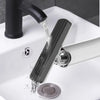 A black compact self-squeezing mini mop is being used to clean a white bathroom sink.