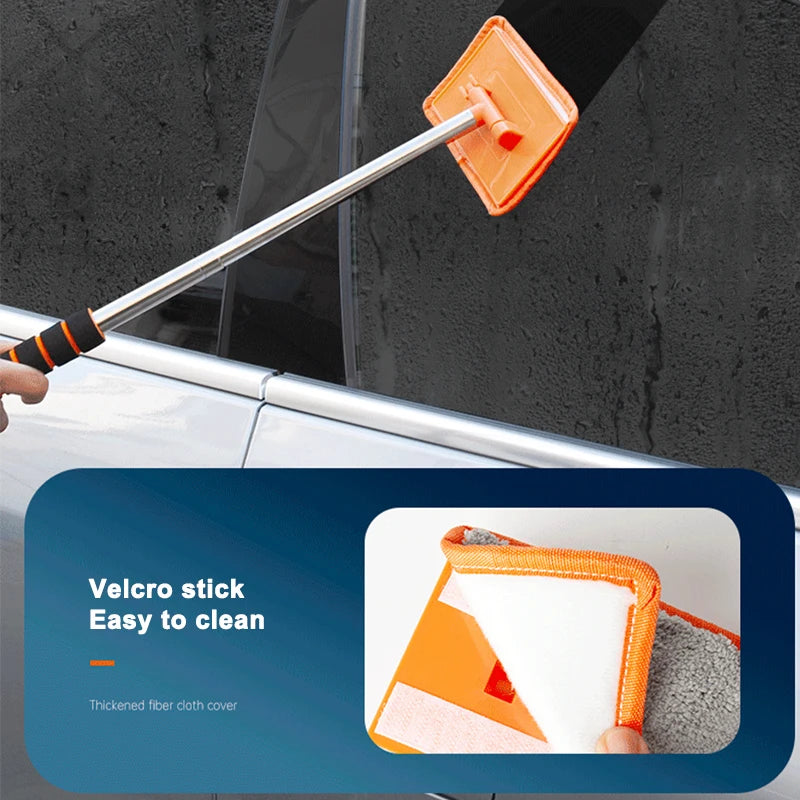 An orange telescopic windshield cleaning brush with a soft, absorbent cloth head is shown against a dark surface.
