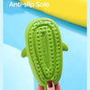 A hand holds a bright green kids shark clog sandal featuring an anti-slip sole.