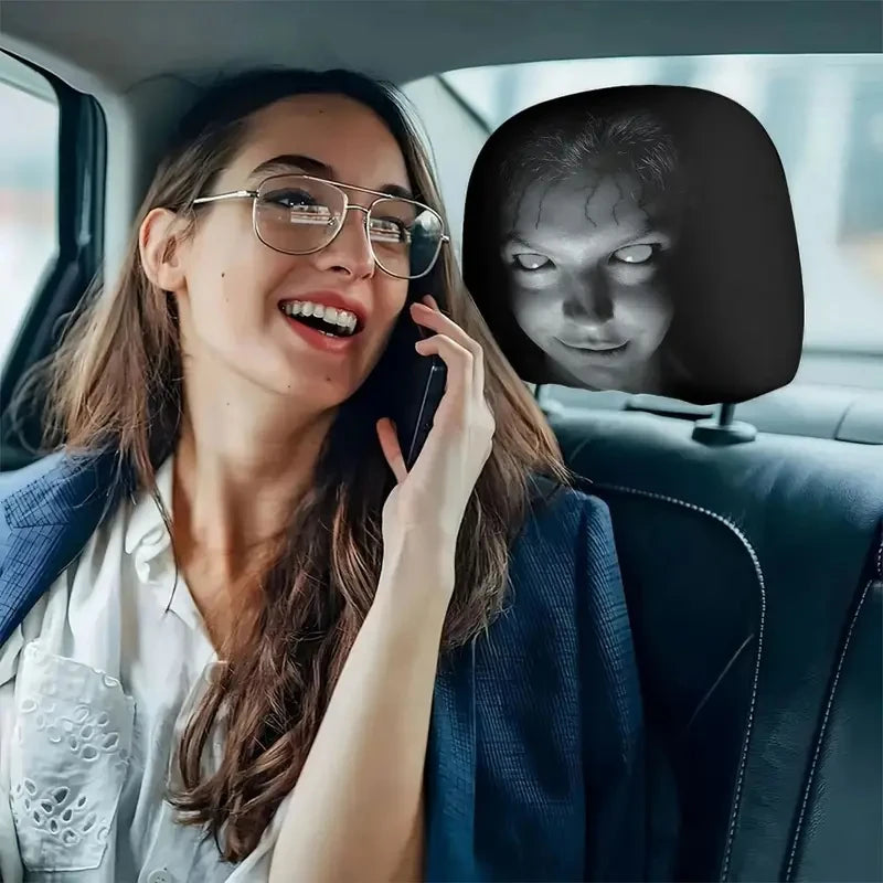 امرأة ترتدي نظارات وسترة زرقاء تنظر إلى شاشة تعرض وجهًا مخيفًا على غطاء مسند رأس السيارة.