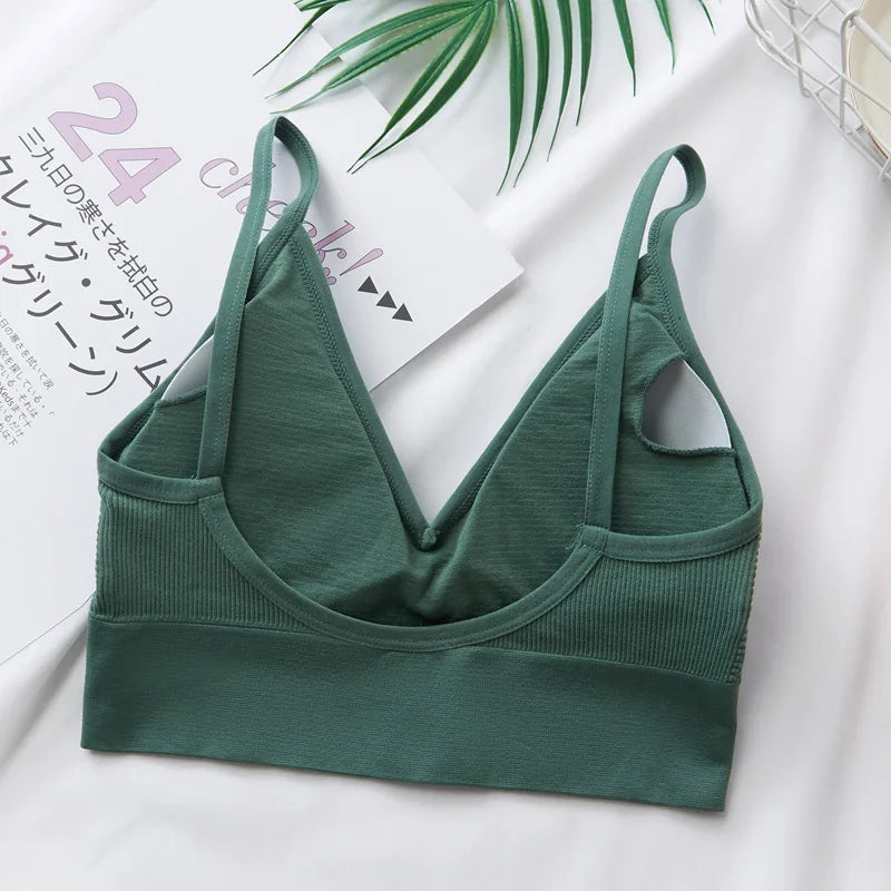 A dark green seamless U-back bralette with removable pads displayed on a white background.