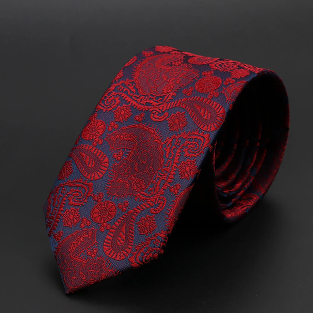 Primer plano de una corbata jacquard roja estampada, doblada y exhibida sobre un fondo oscuro.