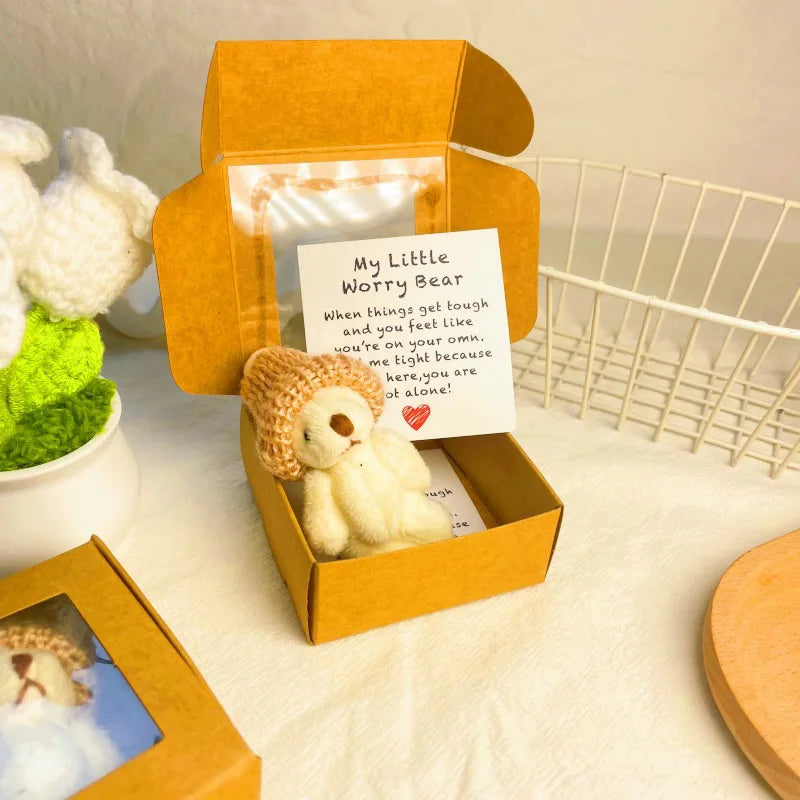Un oso de bolsillo artesanal en una caja de madera con una nota que anima a ser fuerte y amado.