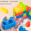 A hand holds a blue rubber building block with a round chamfer edge, next to a colorful set of large blocks.