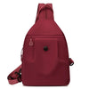 A maroon lightweight oxford cloth mini backpack shown from the back.
