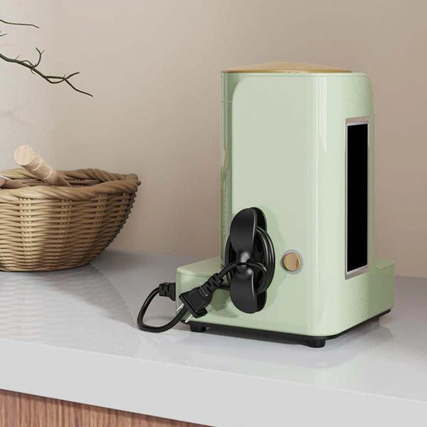 A light green cable management clip with an adhesive mount is displayed on a white surface.