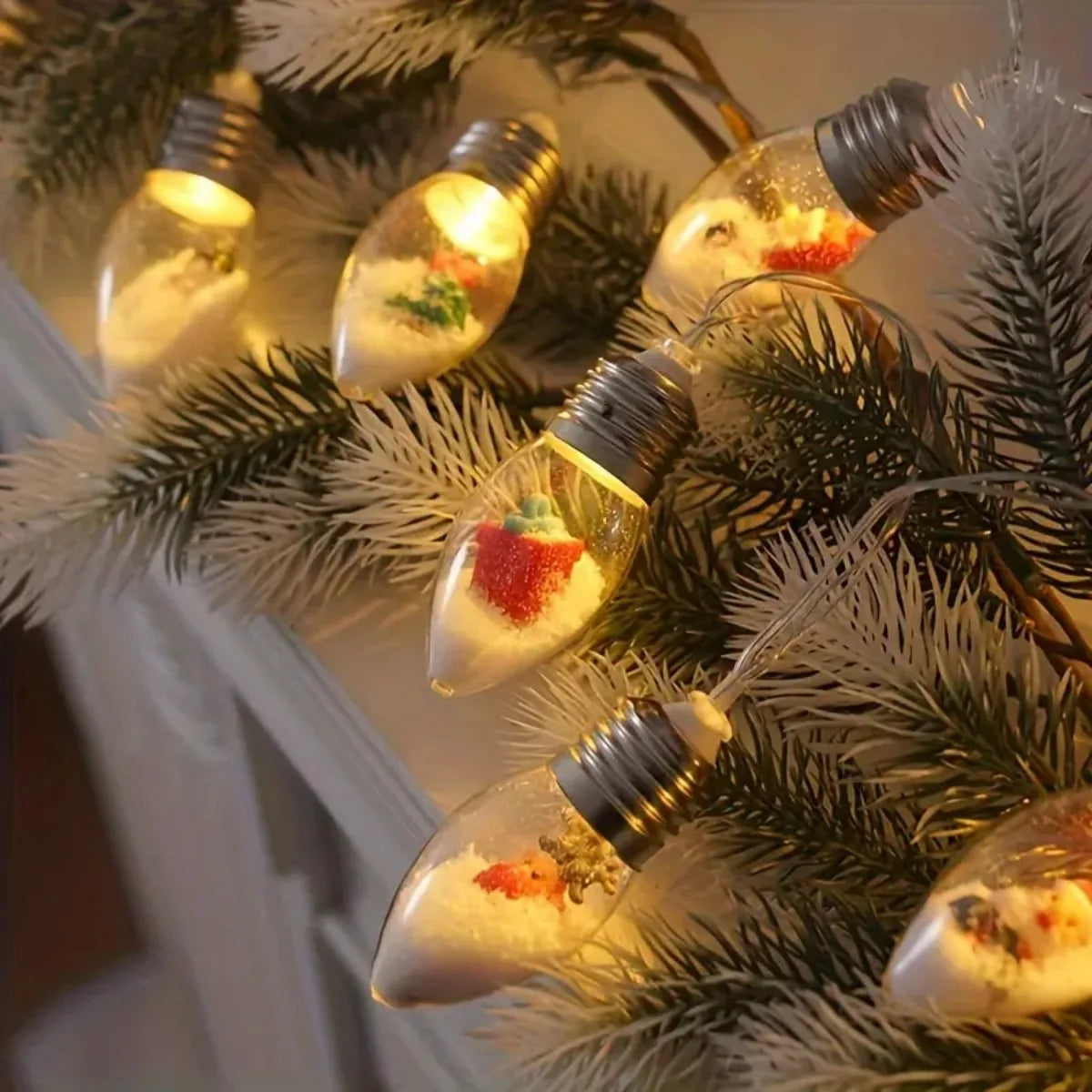 Julelys med batteridrevne LED-snøballpærer og festlige anheng på furugrener