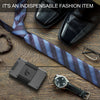 Cartera delgada de aluminio con bolsillo elástico para tarjetas y correa para efectivo, junto a una corbata y zapatos de vest