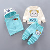 A three-piece cartoon loungewear set for kids featuring a light blue fleece jacket, pants, and a matching bear graphic.